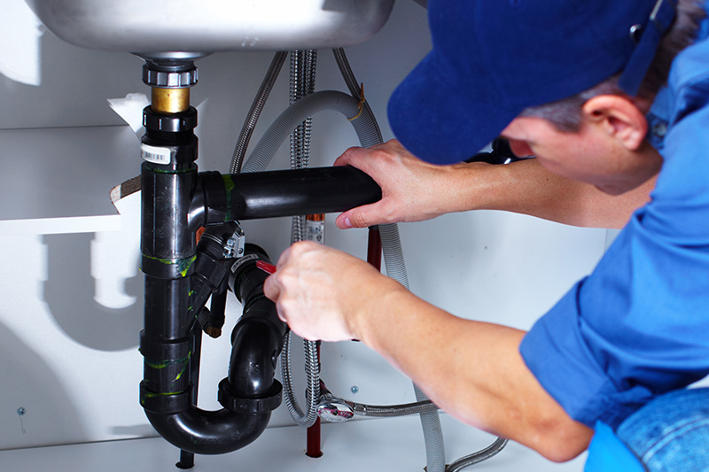 Image of a technician fixing a sink
