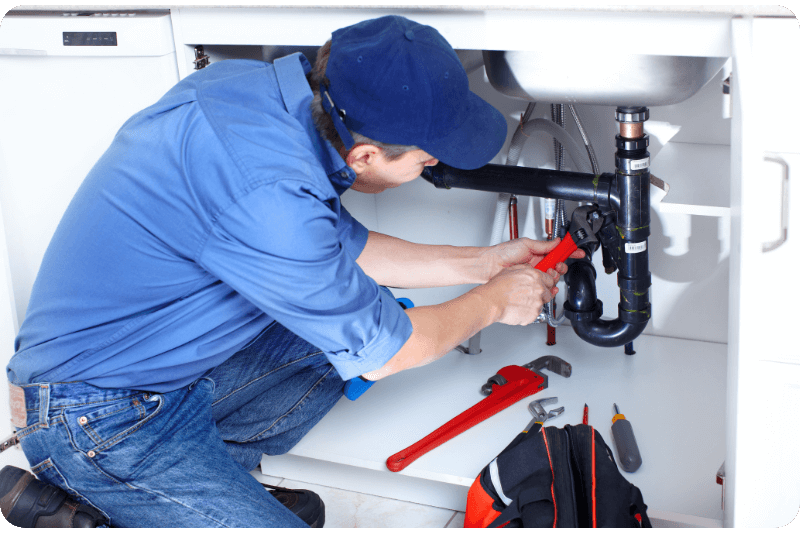 plumber working under sink
